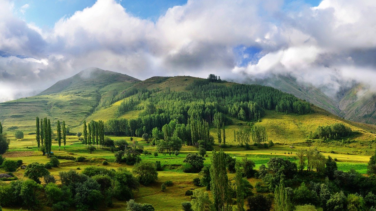 Eine wunderschöne grüne Landschaft mit Bergen und Wolken am Horizont